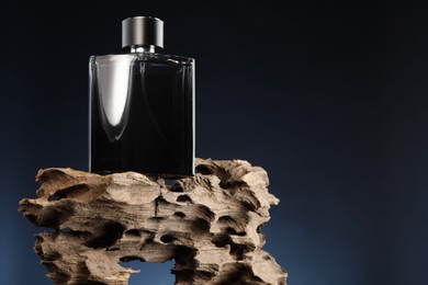 Luxury men`s perfume in bottle against dark background, space for text