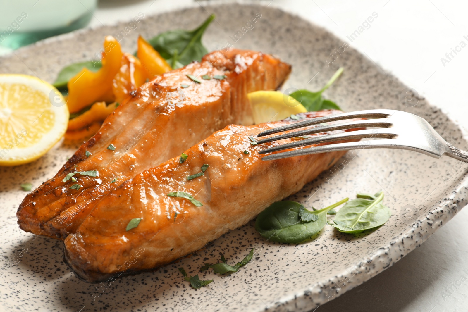 Photo of Tasty cooked salmon with lemon on plate, closeup