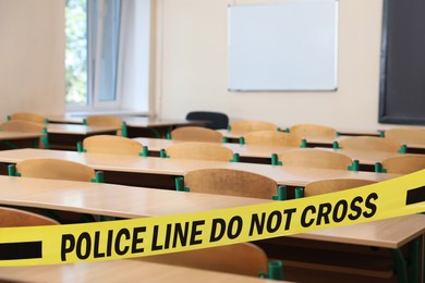 Image of Yellow crime scene tape in empty school classroom