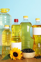 Bottles of cooking oil, sunflower and seeds on wooden table