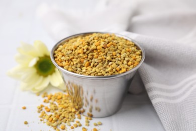 Photo of Fresh bee pollen granules on white table, closeup