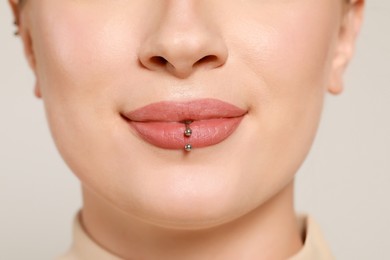 Photo of Young woman with lip piercing on white background, closeup