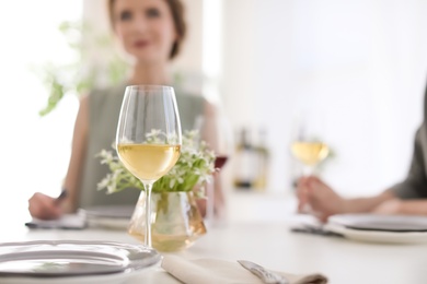 Photo of Glass of wine and blurred couple on background