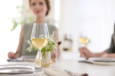 Glass of wine and blurred couple on background