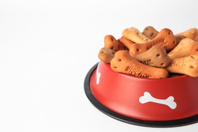 Bone shaped dog cookies in feeding bowl on white background, closeup. Space for text