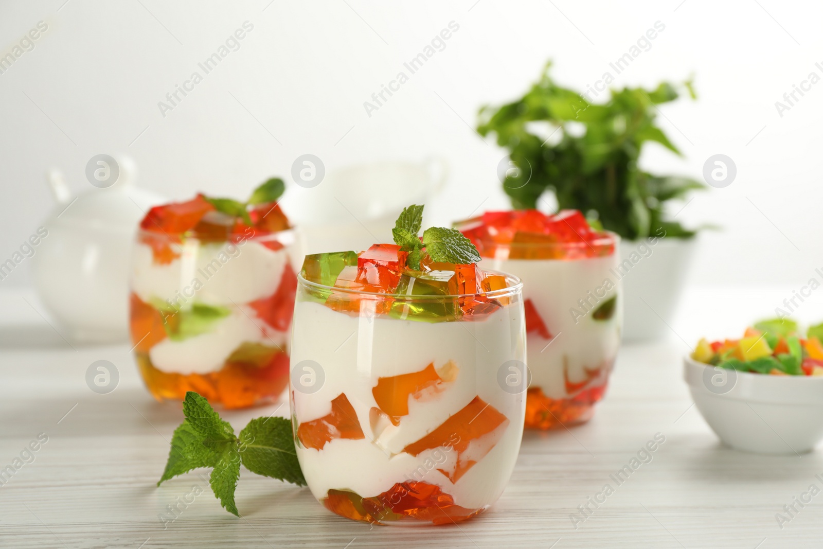 Photo of Delicious broken glass jelly dessert on white wooden table