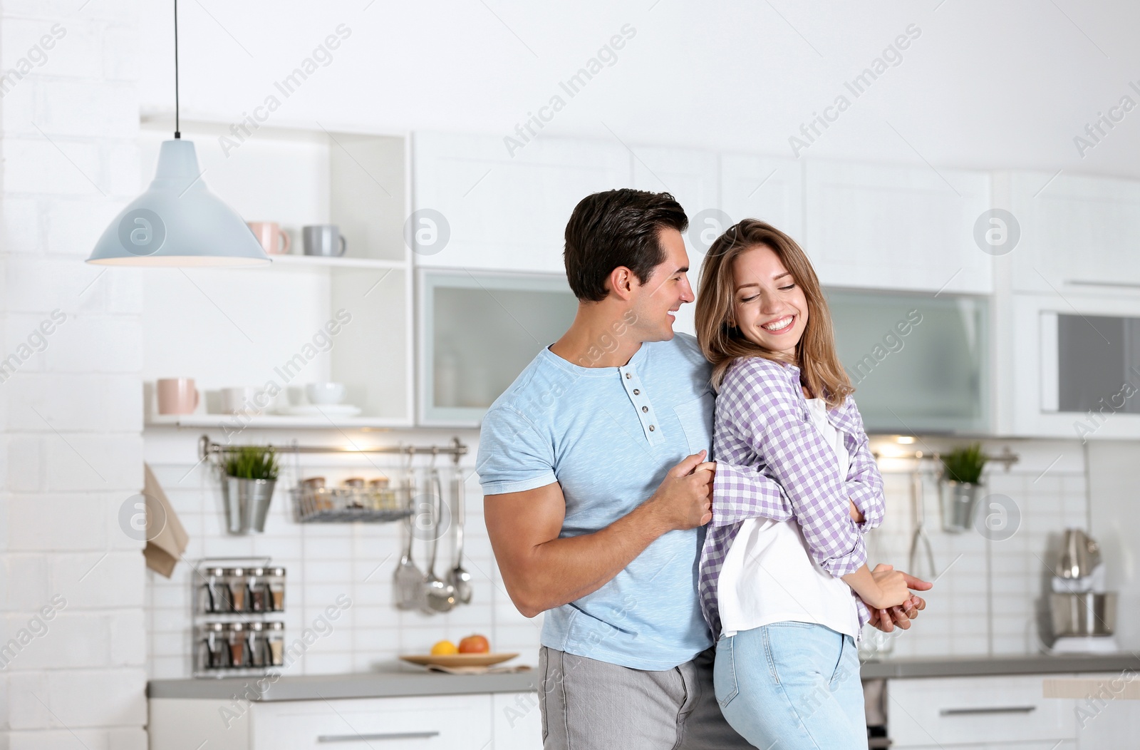 Photo of Beautiful young couple dancing in kitchen at home