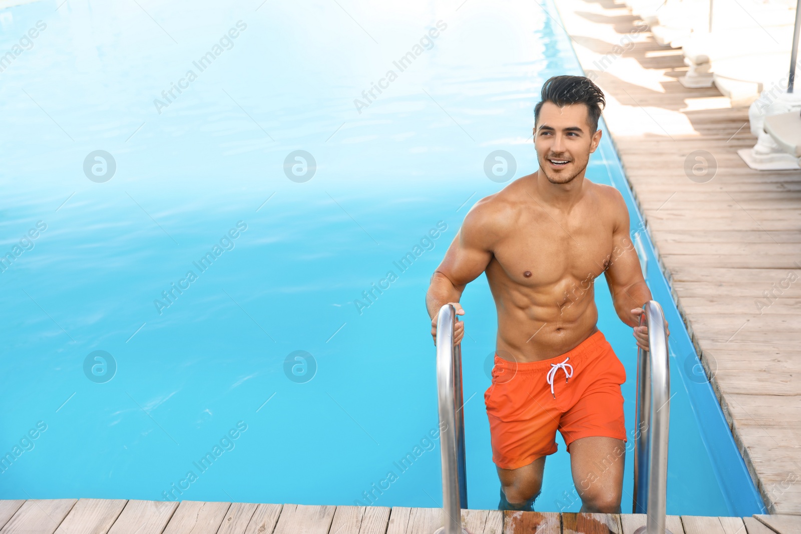 Photo of Young man getting out of outdoor pool, space for text