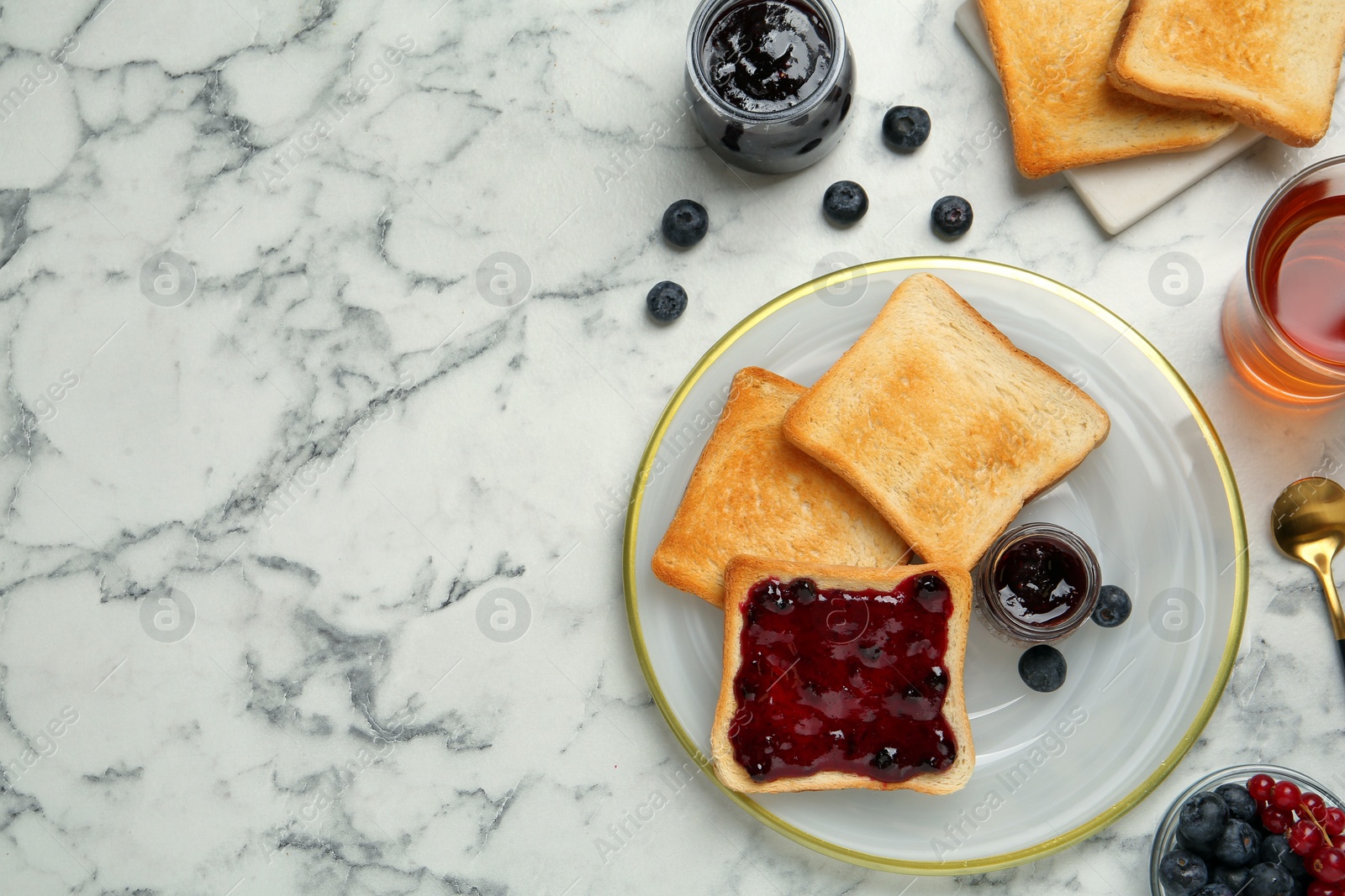 Photo of Delicious toasts served with jam, tea and berries on white marble table, flat lay. Space for text