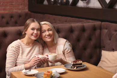 Photo of Mother and her adult daughter spending time together in cafe