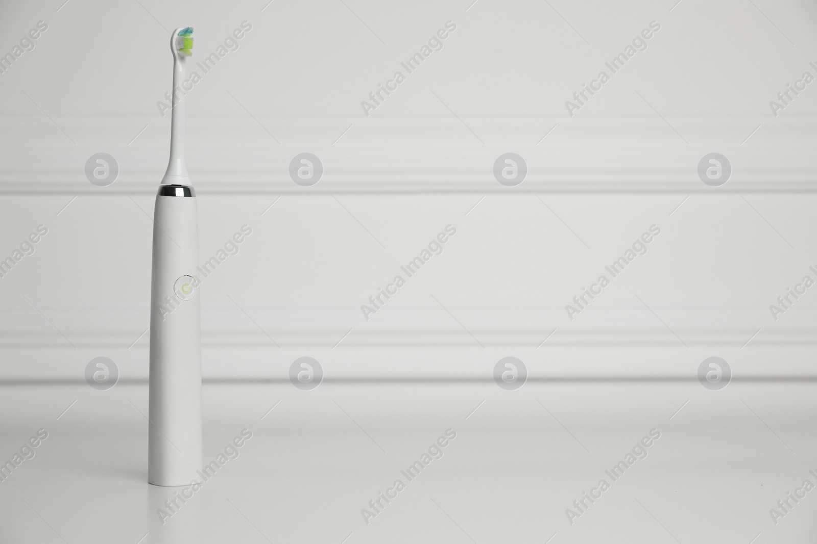 Photo of Electric toothbrush on white background, space for text