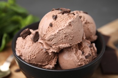 Photo of Bowl with tasty chocolate ice cream on blurred background, closeup