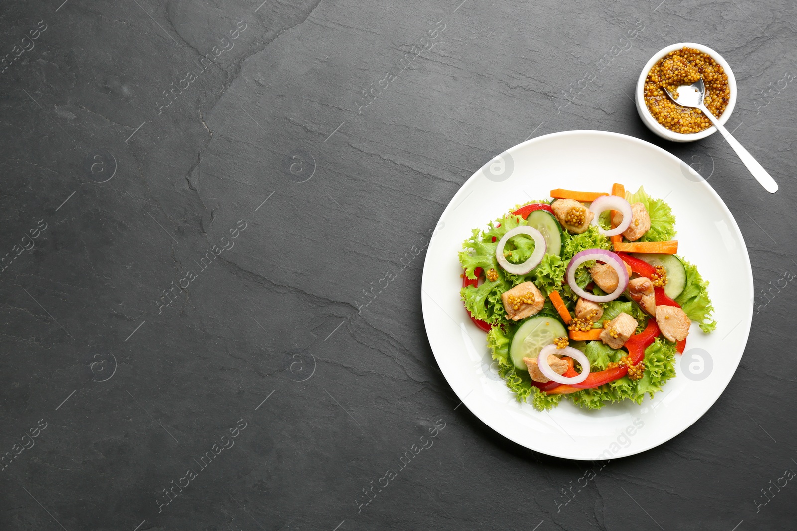 Photo of Delicious fresh chicken salad served on black table, flat lay. Space for text