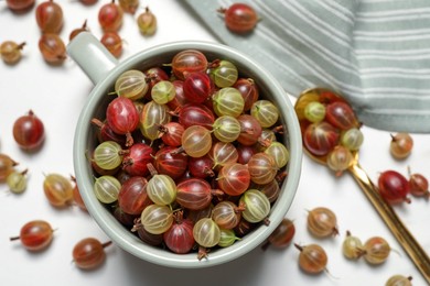 Photo of Fresh ripe gooseberries on white table, flat lay