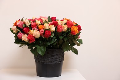 Photo of Bouquet of beautiful roses on table against light background. Space for text