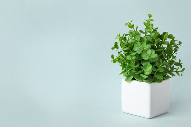 Photo of Beautiful artificial plant in flower pot on grey background, space for text