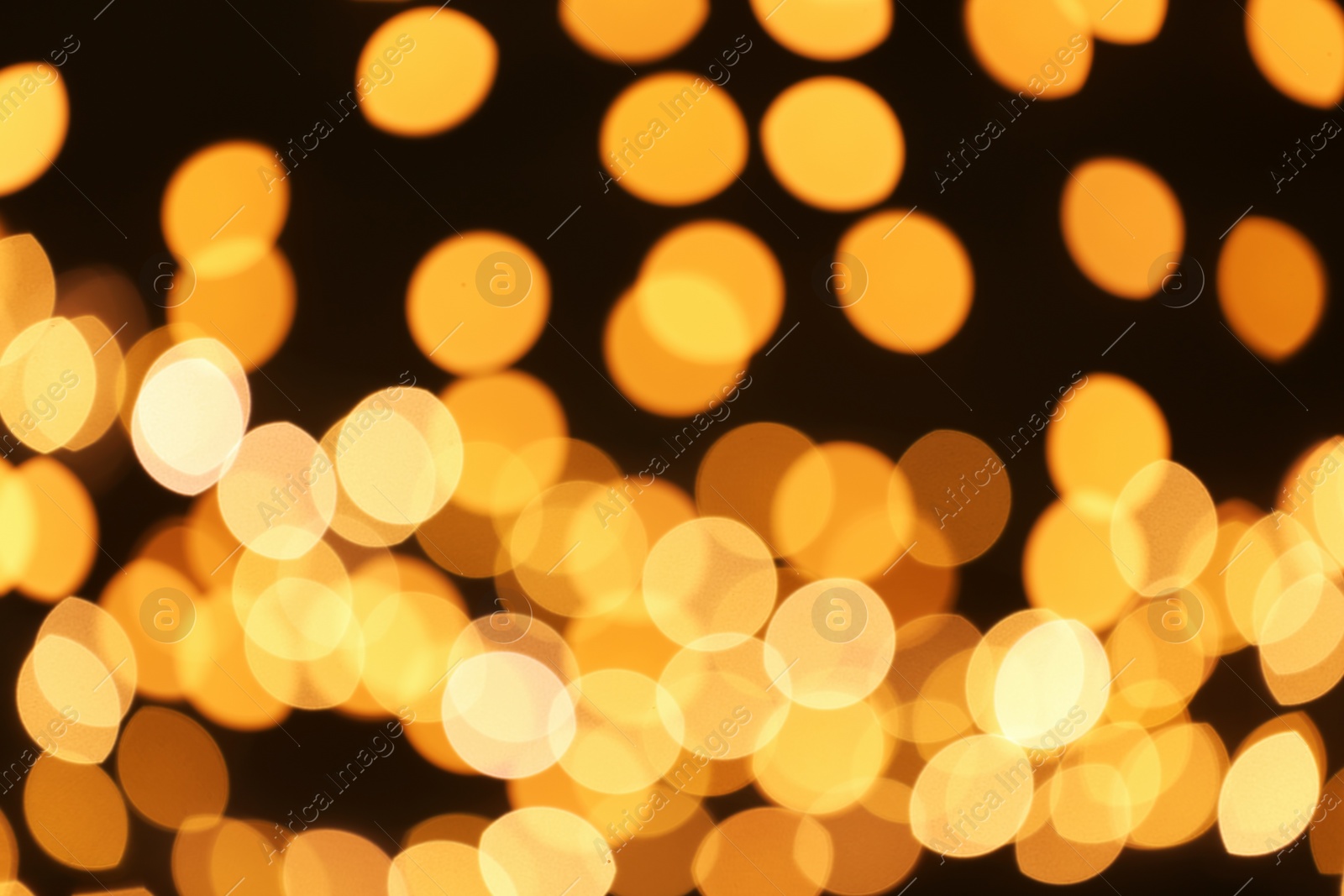 Photo of Beautiful golden lights on dark background. Bokeh effect