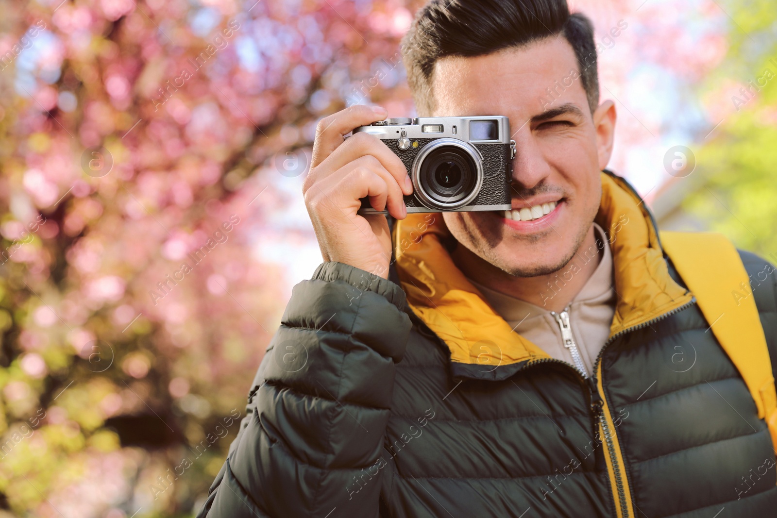 Photo of Happy male tourist with camera outdoors on spring day