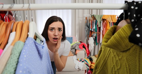 Image of Young woman with lots of clothes in room, banner design. Fast fashion