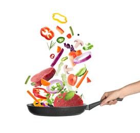 Image of Woman holding nonstick frying pan with falling beef slices and vegetables on white background. Process of cooking