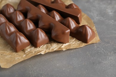 Photo of Tasty chocolate bars on grey table, closeup. Space for text