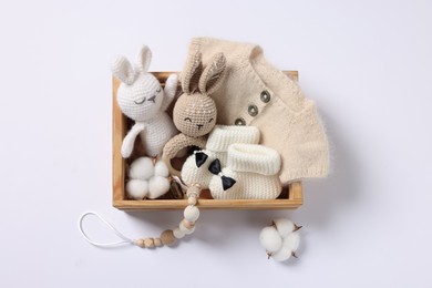 Photo of Different baby accessories and clothes in wooden crate on white background, top view
