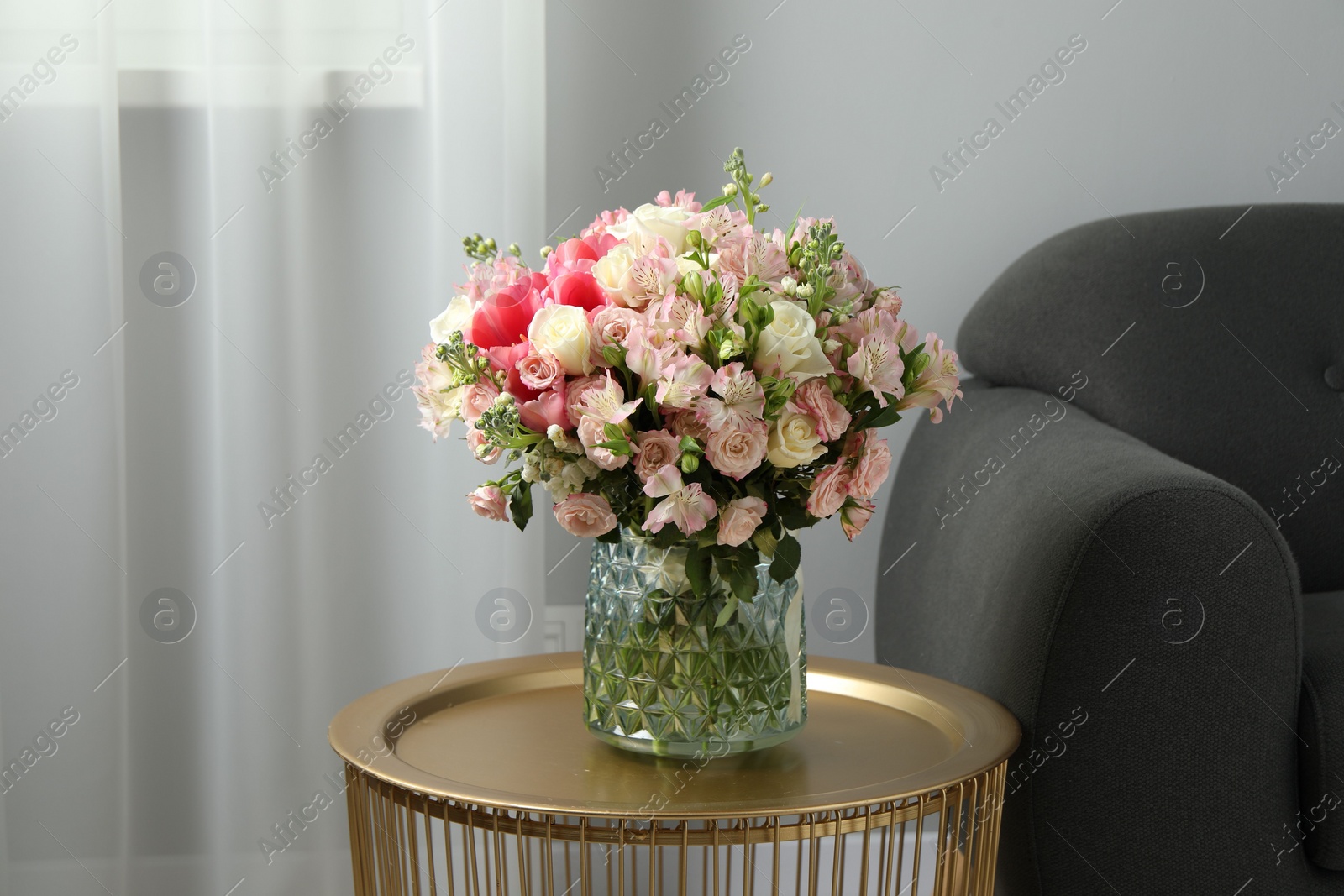 Photo of Beautiful bouquet of fresh flowers on coffee table in room, space for text