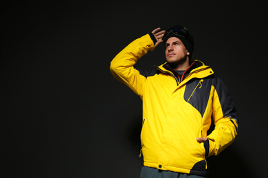 Photo of Man wearing stylish winter sport clothes on black background