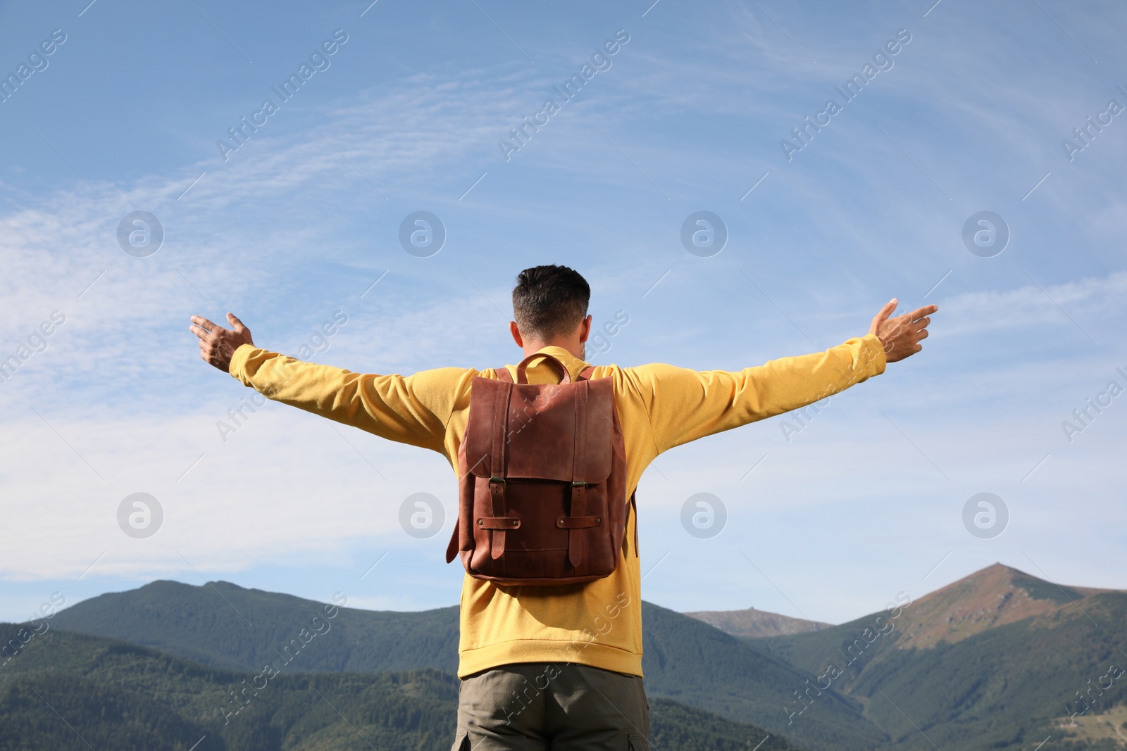 Photo of Man enjoying beautiful mountain landscape, back view