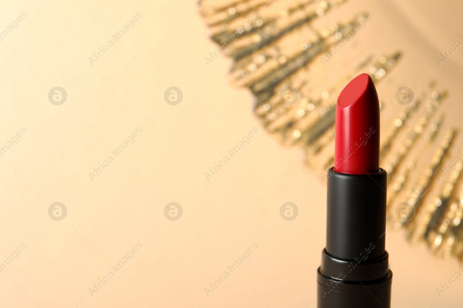 Photo of Beautiful red lipstick on beige background, space for text