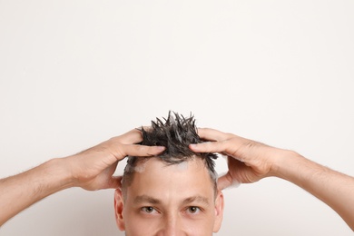 Photo of Man washing hair on white background, closeup