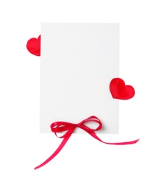 Photo of Blank card with red bow and red decorative on white background, top view. Valentine's Day celebration