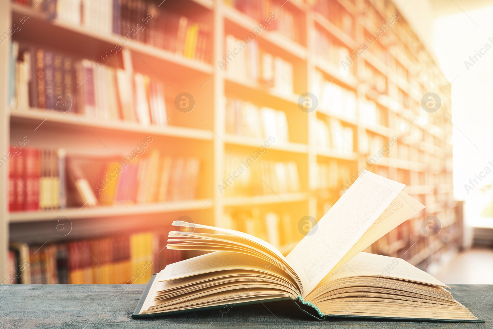 Image of Open hardcover book on table in library