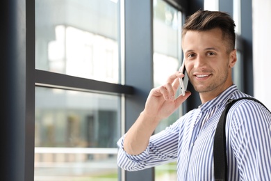 Male business trainer talking on phone in office