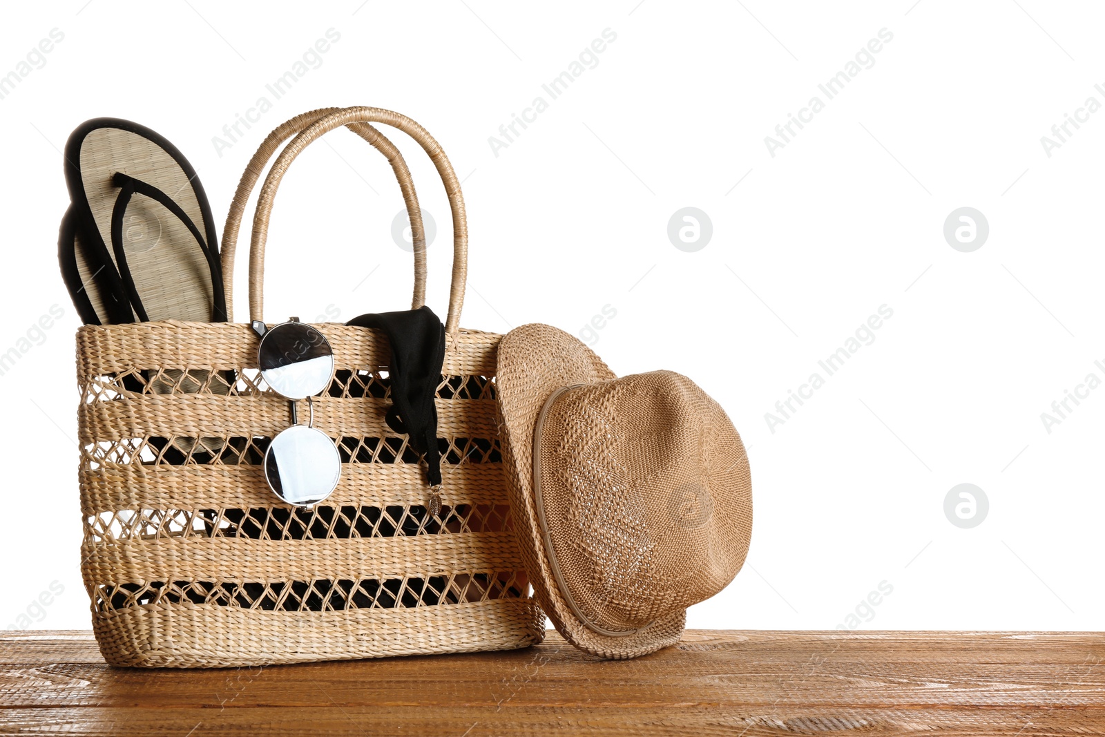 Photo of Set of beach accessories on wooden table, white background