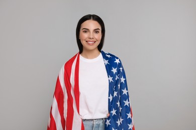 4th of July - Independence Day of USA. Happy woman with American flag on light grey background