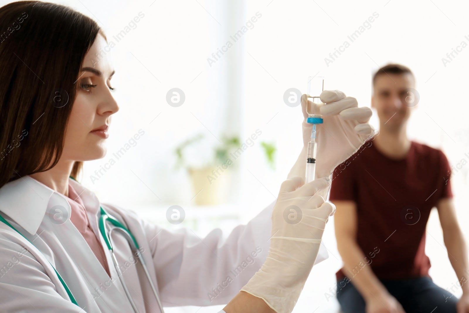 Photo of Doctor holding ampule with vaccine and syringe for patient in clinic