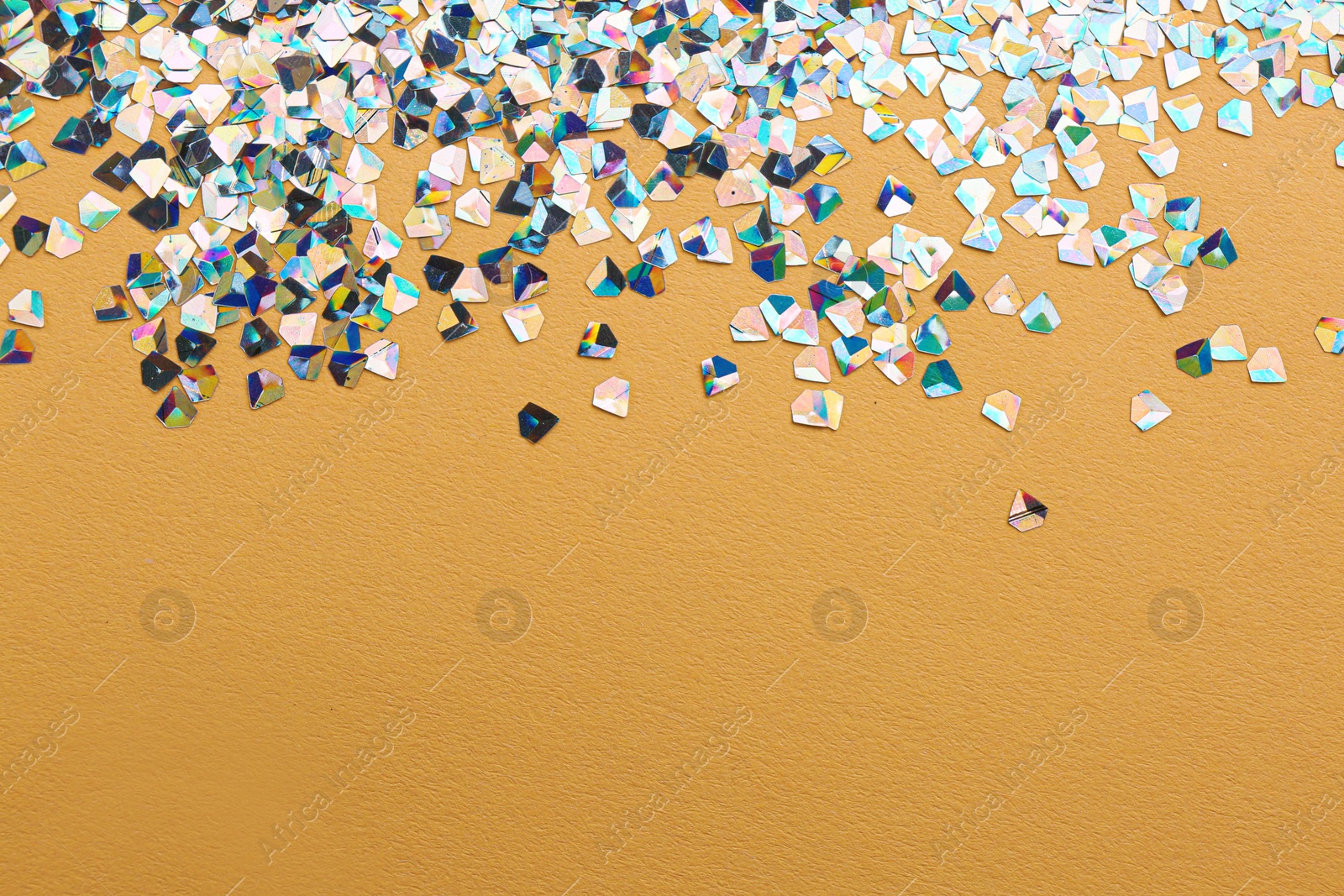 Photo of Shiny bright glitter on beige background. Space for text