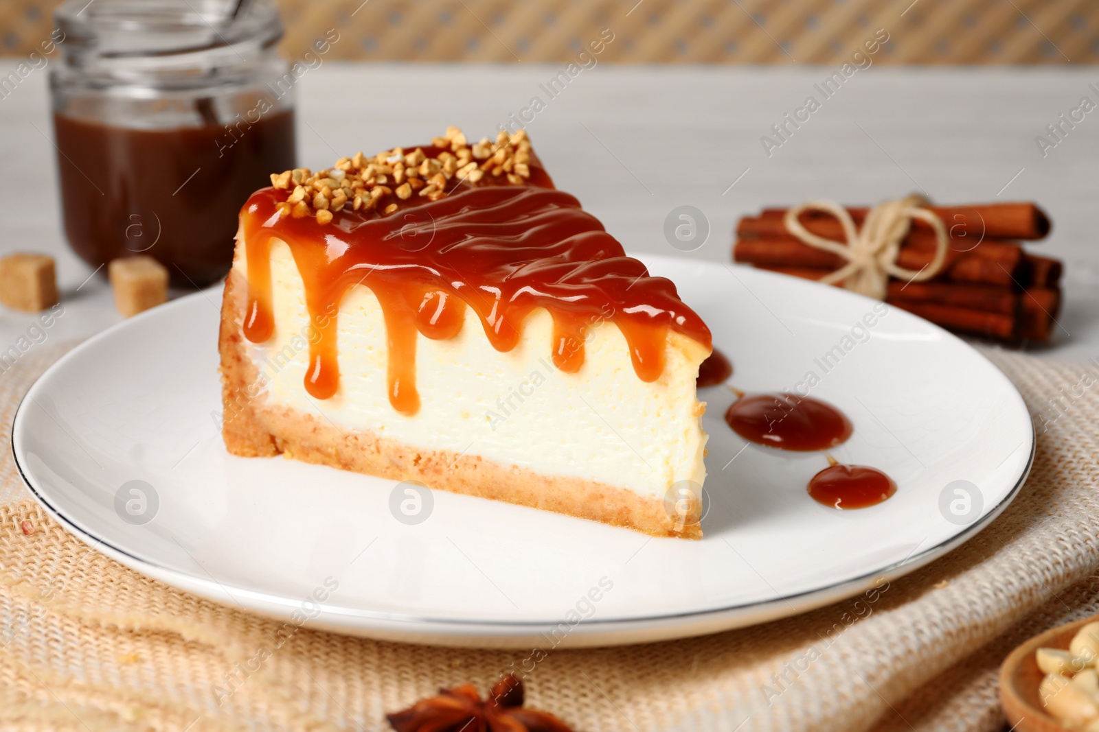 Photo of Tasty cheesecake with caramel and nuts served on table