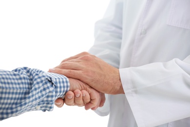 Photo of Doctor holding elderly patient hand on light background, closeup