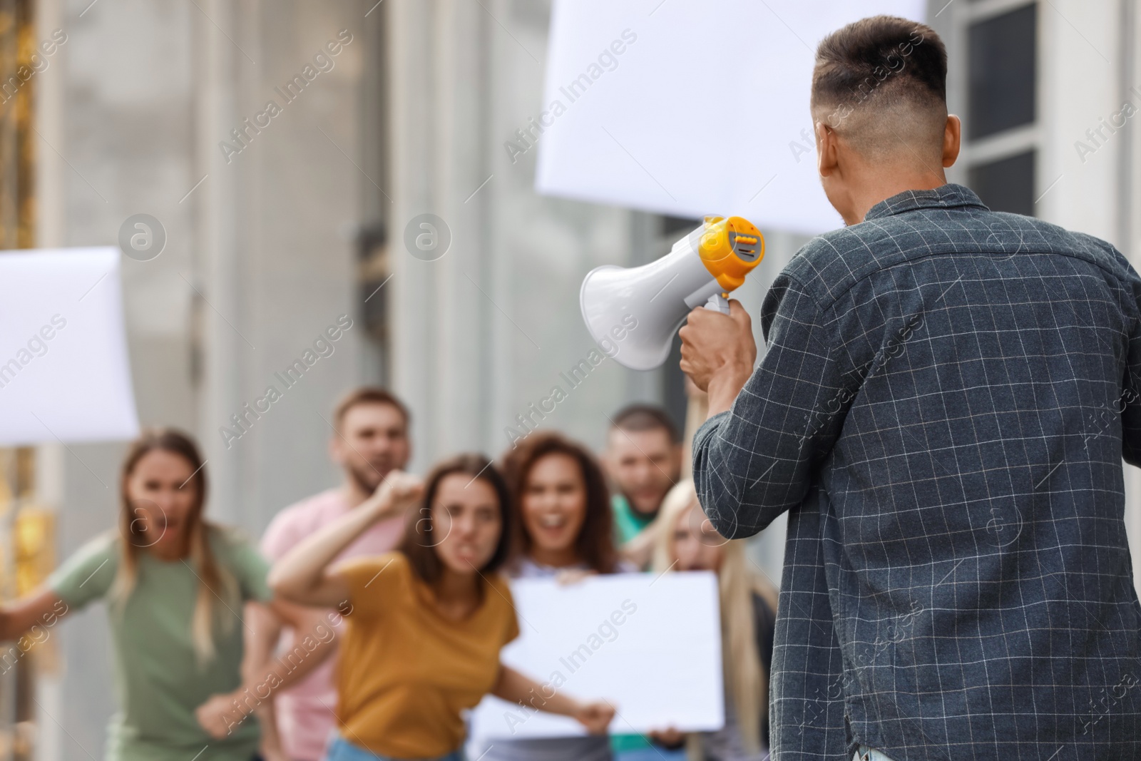 Image of Protest leader with megaphone talking to crowd outdoors