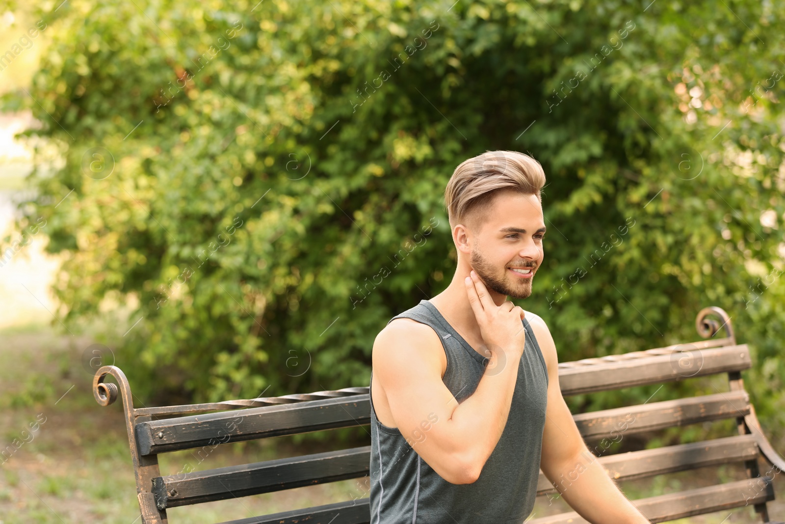 Photo of Young man checking pulse outdoors on sunny day