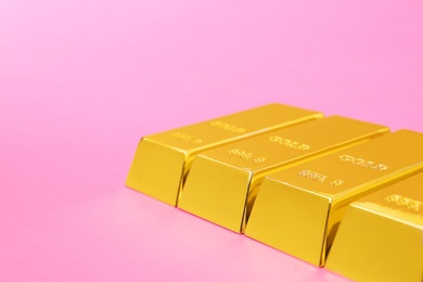 Photo of Precious shiny gold bars on color background. Space for text