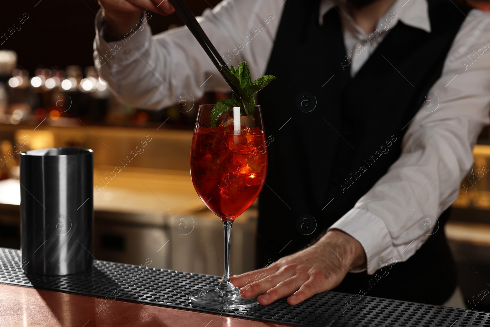 Photo of Bartender making fresh alcoholic cocktail at bar counter, closeup