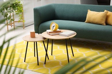 Spring interior. Yellow clock, books and candle on wooden table in living room