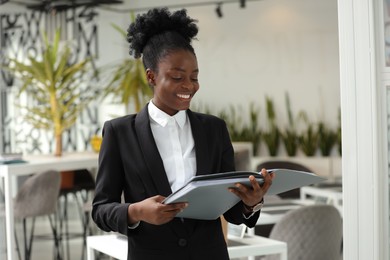 Photo of Happy woman with folders in office. Lawyer, businesswoman, accountant or manager