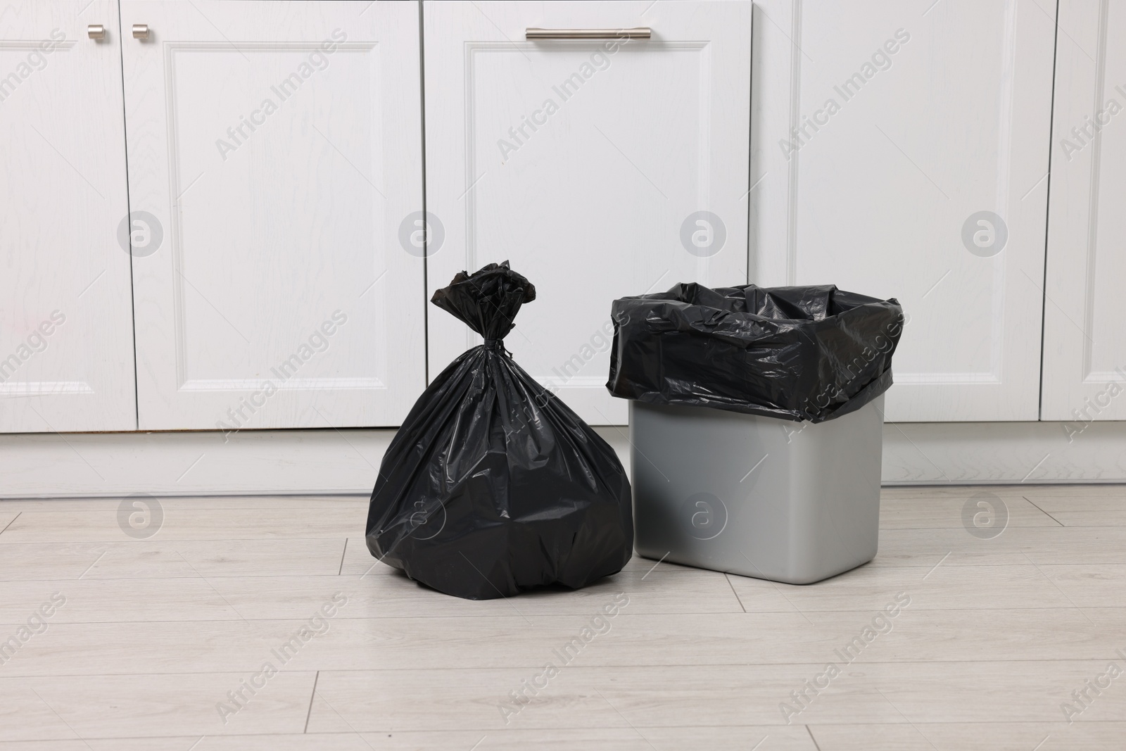 Photo of Plastic garbage bag and trash can indoors