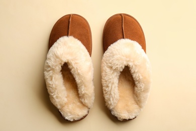 Pair of stylish soft slippers on beige background, flat lay