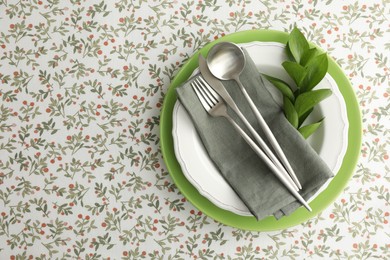 Stylish setting with cutlery, plates, napkin and floral decor on table, top view. Space for text