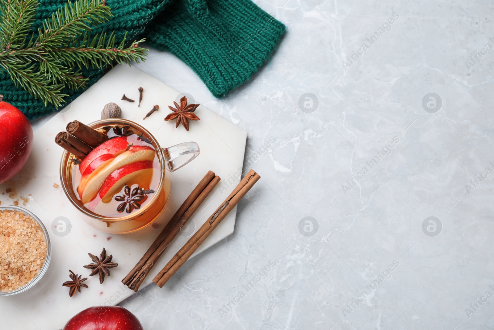 Photo of Aromatic hot mulled cider on light grey marble table, flat lay. Space for text